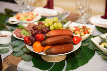 Brown bananas in a fruit bowl. Vegan food on the festive table.