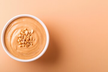 Creamy peanut spread in bowl garnished with crushed peanuts, war