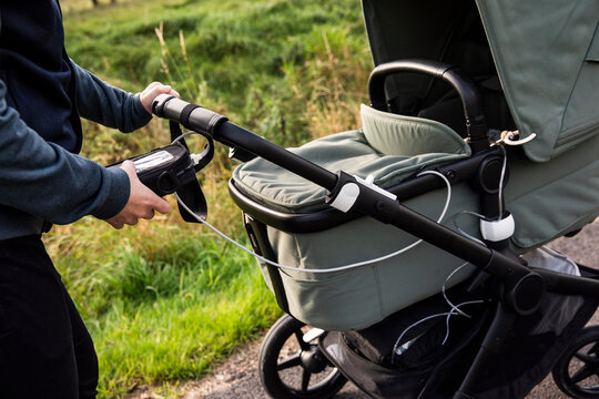 Midsection of woman monitoring heart rate on equipment attached to stroller