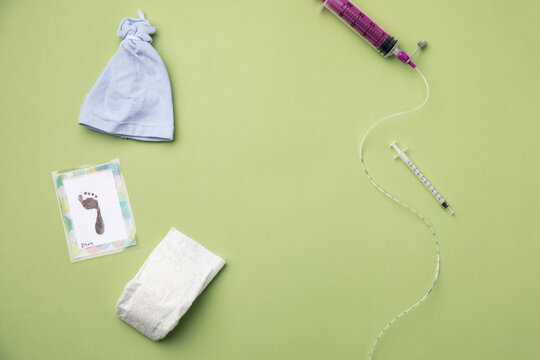 Medical equipment with baby goods on green background