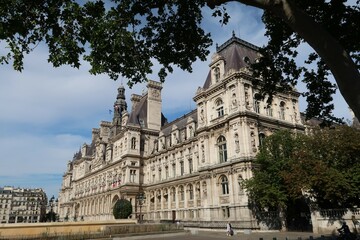 Obraz premium Façade de l’hôtel de ville / mairie de Paris, célèbre monument historique parisien, avec un arbre devant le bâtiment (France)