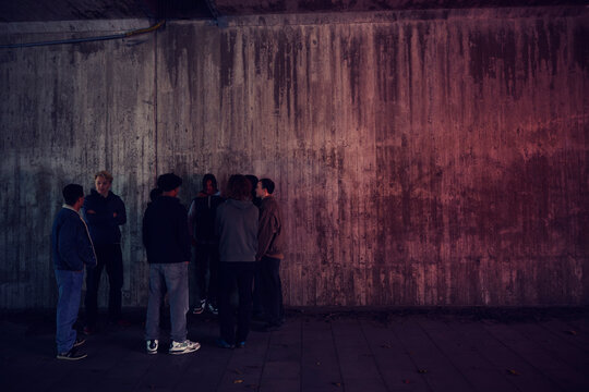 Group of young friends standing against textured wall