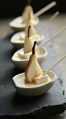 Elegant pear and Brie canapés with honey drizzle served on a stone with dark background