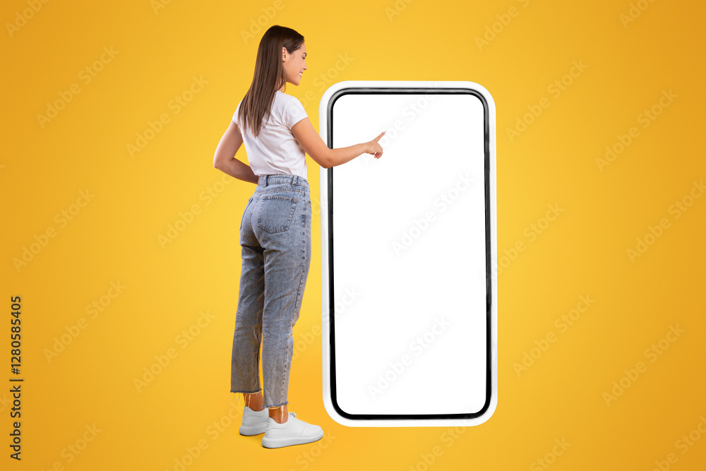 Poster full body length back view of woman using big smartphone with blank white screen and touching displa