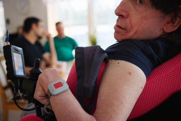 Mature man with cerebral palsy wearing emergency call button bracelet