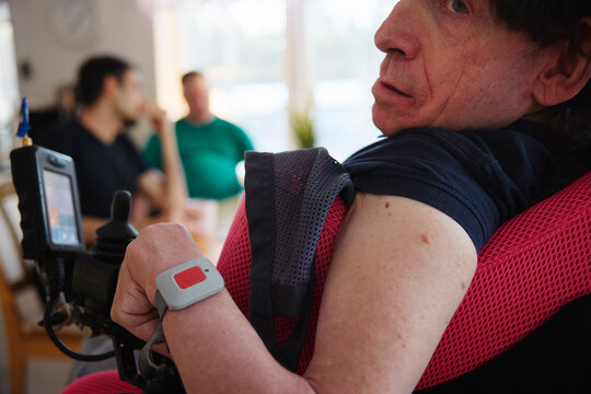 Mature man with cerebral palsy wearing emergency call button bracelet