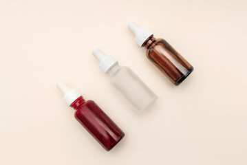 variety of dropper bottles of essential oil or serum on a beige background,wellness and skincare cosmetics