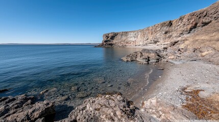 Obraz premium Coastal rocky beach, calm water, clear sky. Possible use Stock photo for travel, nature