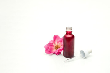 Rose dropper bottle of cosmetic serum or essential oil for skincare and wellness treatment on white background