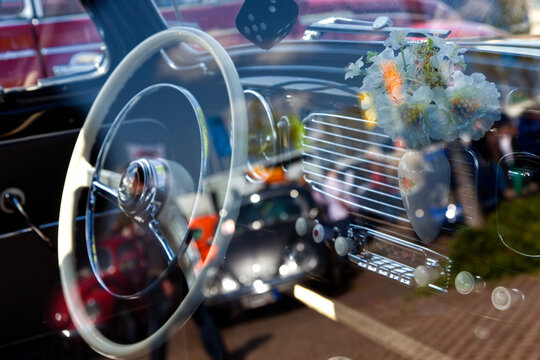 Fototapeta Interior of vintage car seen through side window, other cars reflected in glass