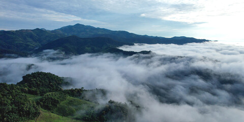 Landscape view of the sea of fog flowing on hills at dawn by drone