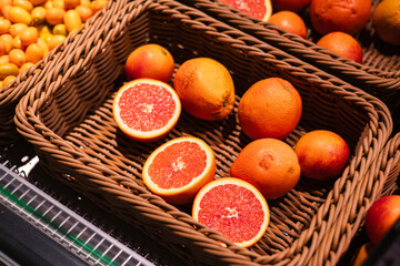 Sliced and whole fresh citrus fruits at market display.