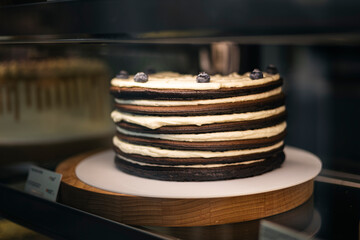 Chocolate pancake cake with cream cheese and jam, decorated with blueberries.
