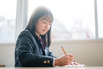 授業を受ける制服を着た女子中学生。
