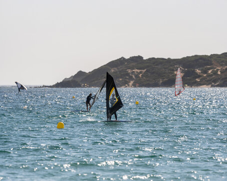 Windsurfers sailing at sunset in the sea near the coast of Tarifa, Spain. - Powered by Adobe