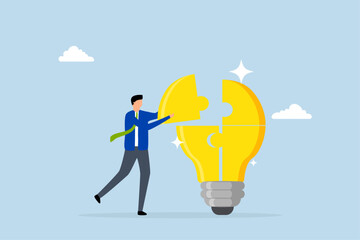 Problem solver, clever entrepreneur completing lightbulb concept puzzle by placing final jigsaw piece. 