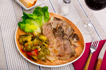 Delicious roasted pork chop served with stewed vegetables