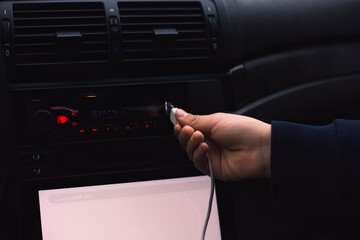 Hand a man plug in USB cable on the car audio