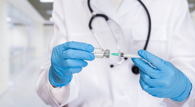 Medical professional preparing vaccine with syringe in clinical setting during daytime