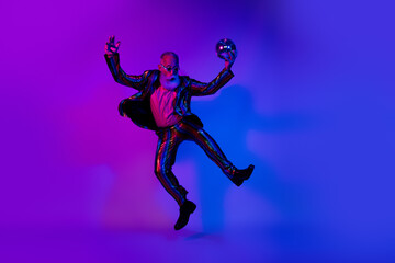 Full length photo of funky cool mature guy dressed glamour costume star eyewear jumping dancing disco emtpy space isolated neon purple color background