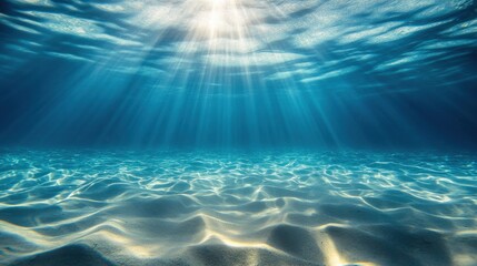 Fototapeta premium Sunlight filters through crystal clear water, illuminating the tranquil sandy ocean floor.