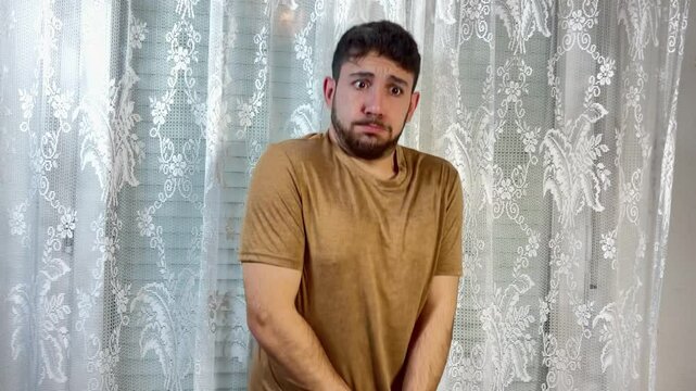 Young man holding his crotch in bathroom suffering from abdominal pain