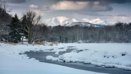Serene winter landscape featuring snow-covered riverbanks and distant mountains under a moody sky with soft gray and white tones.