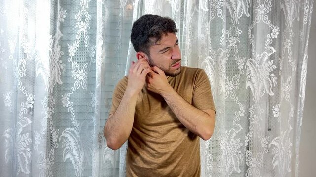 Man suffering from earache touching his ear and jaw