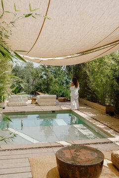 A woman enjoys a private villa with a pool in Fethiye, T&uuml;rkiye, surrounded by lush greenery and natural elegance. A peaceful retreat blending luxury, relaxation, and nature