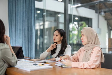 Women discussing project strategies in a contemporary office setting.