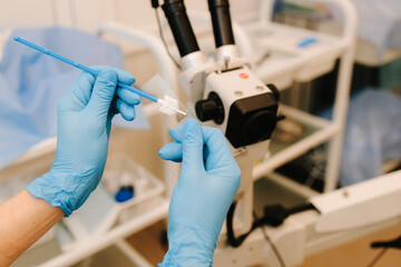 Gynecologist prepares vaginal smear for bacterial examination. Preparing gynecological equipment...