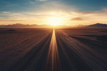 Fototapeta premium Straight Desert Highway Leading Towards Sunset with Clear Sky and Mountains in Horizon