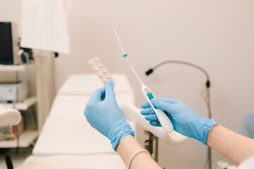 Gynecologist holds contraceptive pills and IUD device in the hands. Medical contraception for...