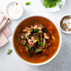 Meat soup with gherkins and olives