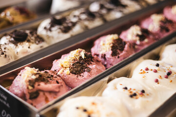 Various cinnamon buns are in trays behind the glass of the showcase.