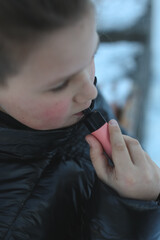 an eleven year old child tries a nicotine-free disposable cigarette on a city street