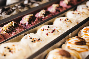 Various cinnamon buns are in trays behind the glass of the showcase.