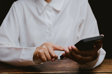Obraz premium Person in White Shirt Using Smartphone with Finger on Screen