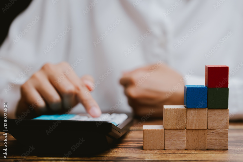 Aufkleber focused person using calculator with wooden blocks on table