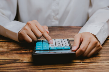 Person Using Calculator with Finger on Button in Office Setting