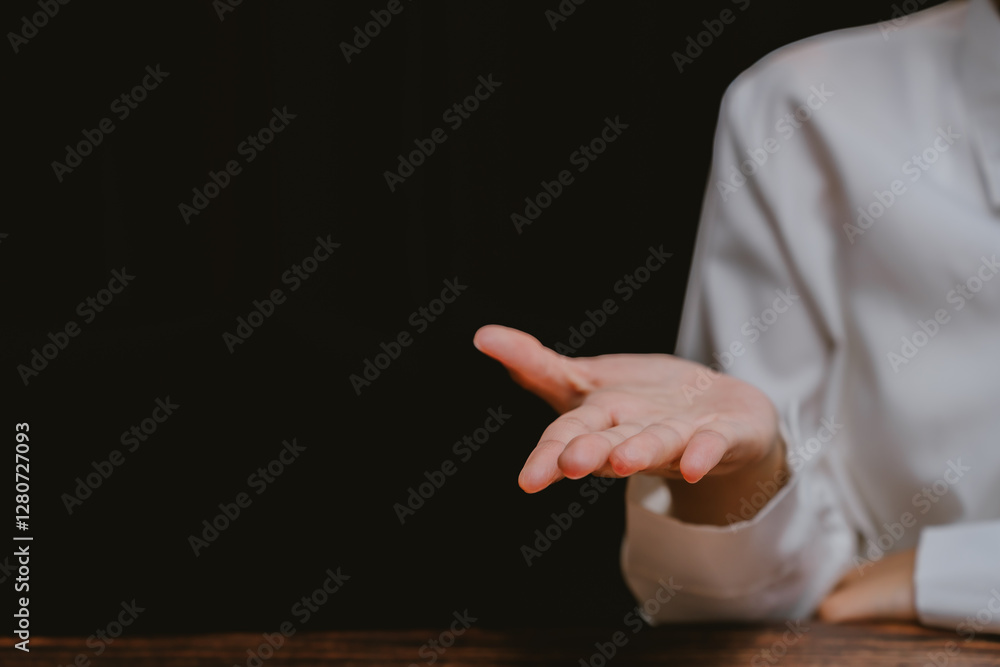 Poster hand gesture in a minimalist setting with dark background