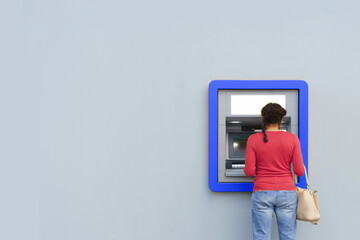 Woman withdrawing money from a cash machine