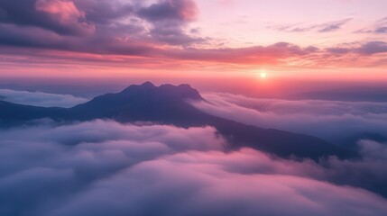 Obraz premium sunset, with clouds below, glowing in soft pinks and purples. The distant peaks emerge from the mist, bathed in golden twilight.