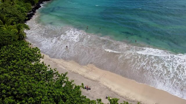 Hamoa Beach Hana Maui Hawaii &ndash; Breathtaking cinematic aerial view of clear blue waters, sizable waves, and lush Hana greenery. A stunning Maui coastal paradise