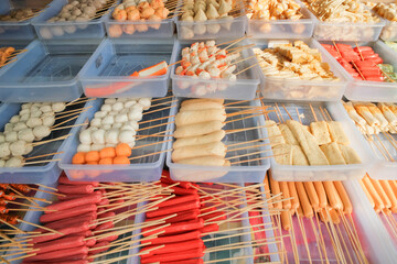 An assortment of various Korean street snacks neatly arranged in trays, showcasing a colorful and appetizing display of popular treats