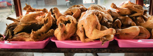 A display of raw chicken, ready to be cooked, piled in abundance at a traditional street food stall...