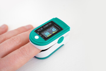 Pulse oximeter used to measure pulse rate and oxygen levels with hand.