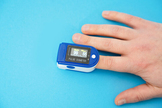 Pulse oximeter used to measure pulse rate and oxygen levels with hand.