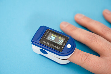 Pulse oximeter used to measure pulse rate and oxygen levels with hand.