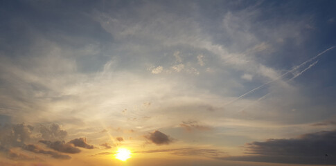 Bright sun on blue sky with clouds. Sunset, horizon skyline background